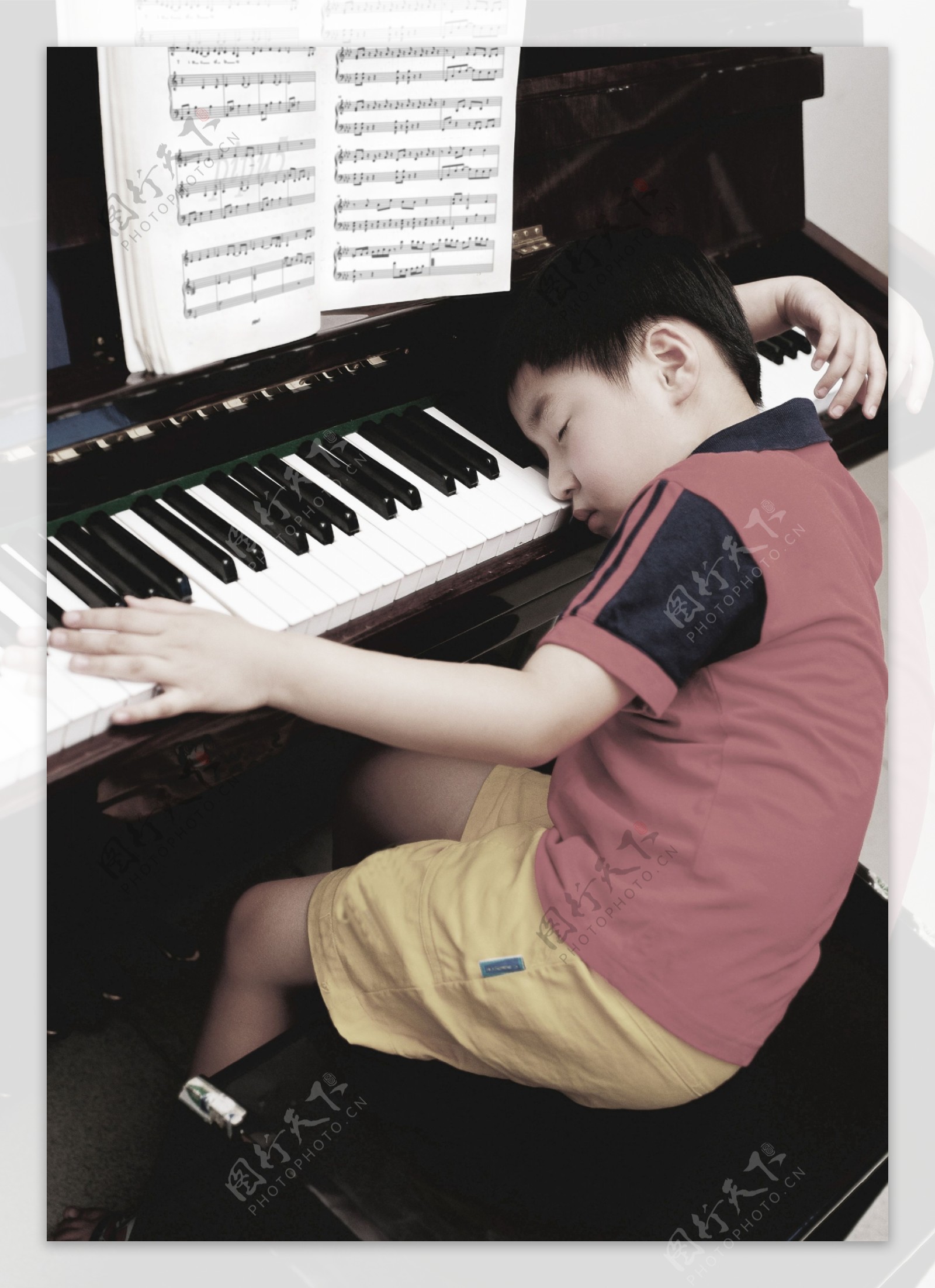 疲劳的儿童学习钢琴图片