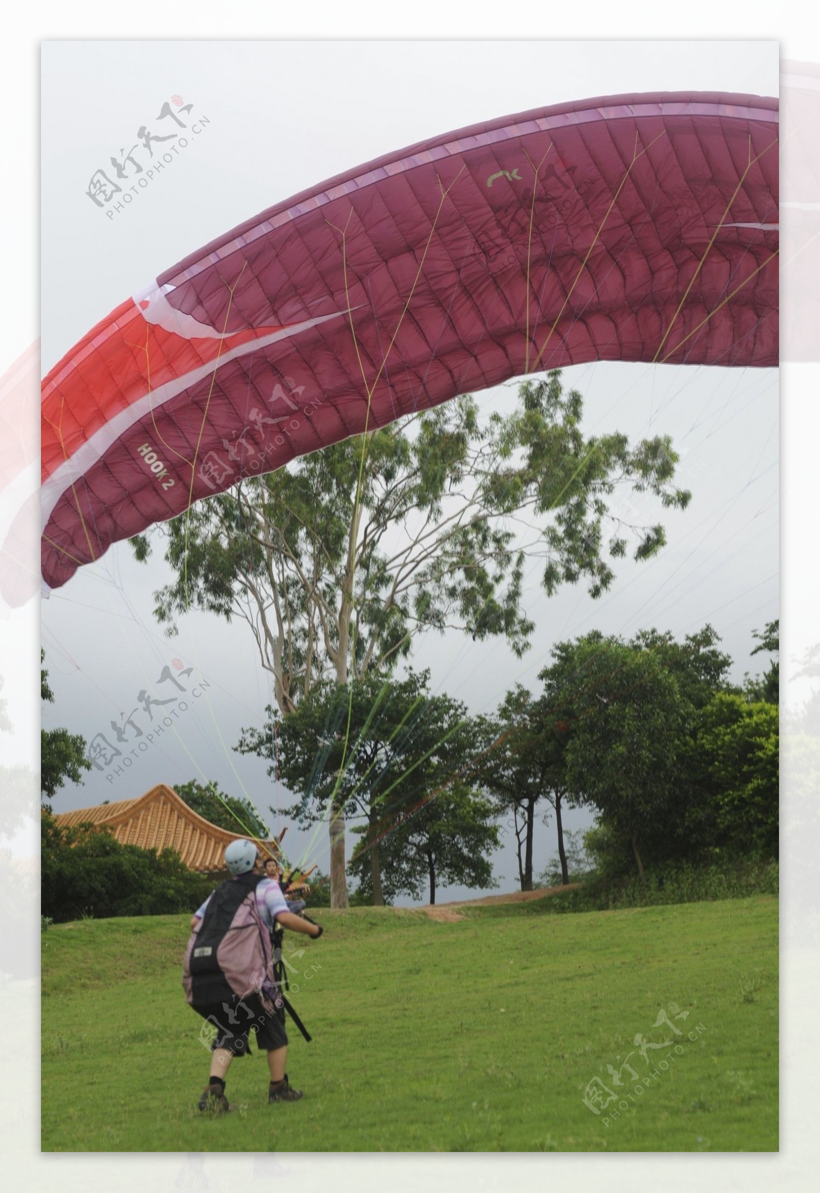 在公园的草坪上逗滑翔伞图片