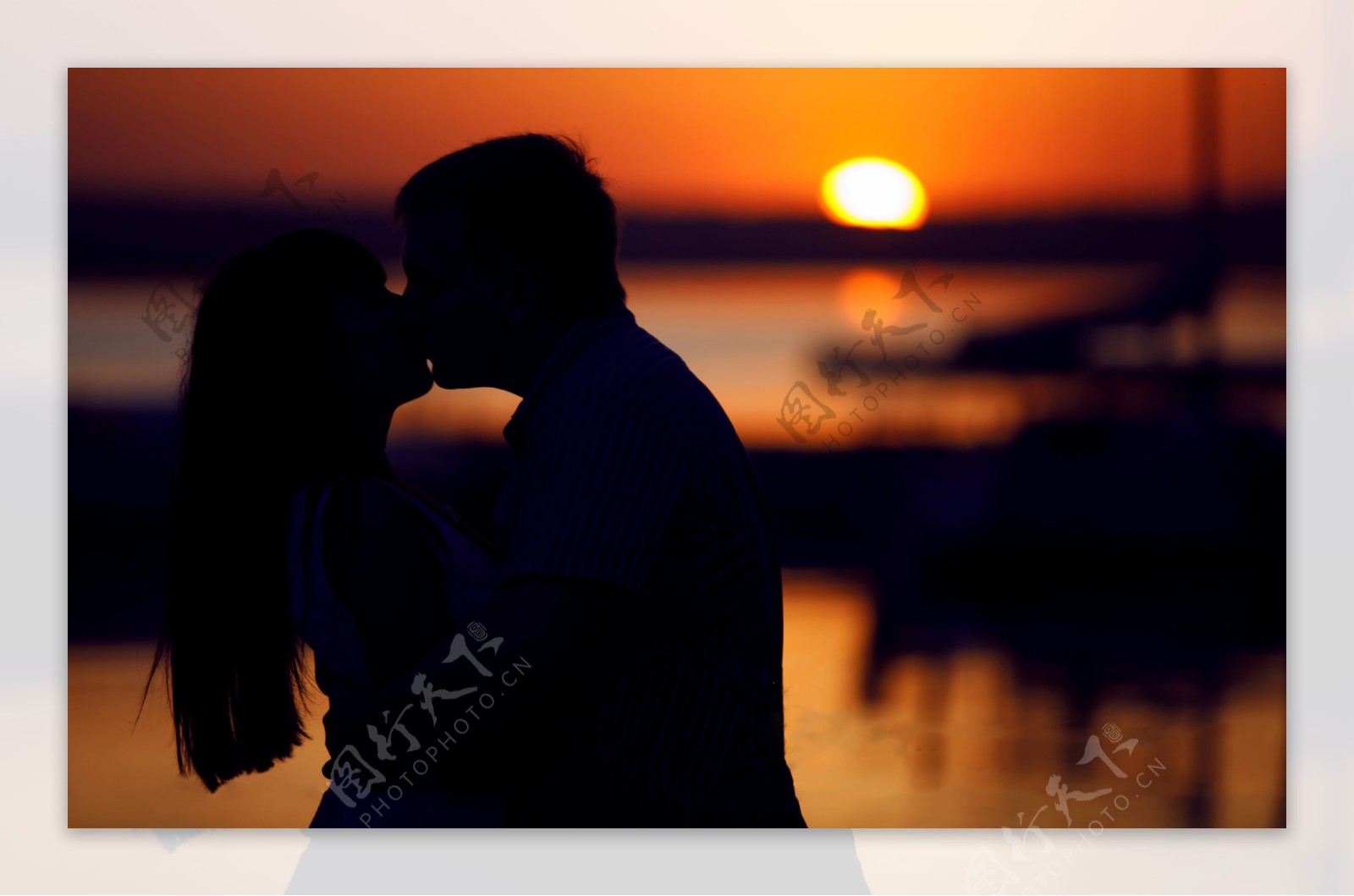 夕阳下亲吻的情侣剪影图片