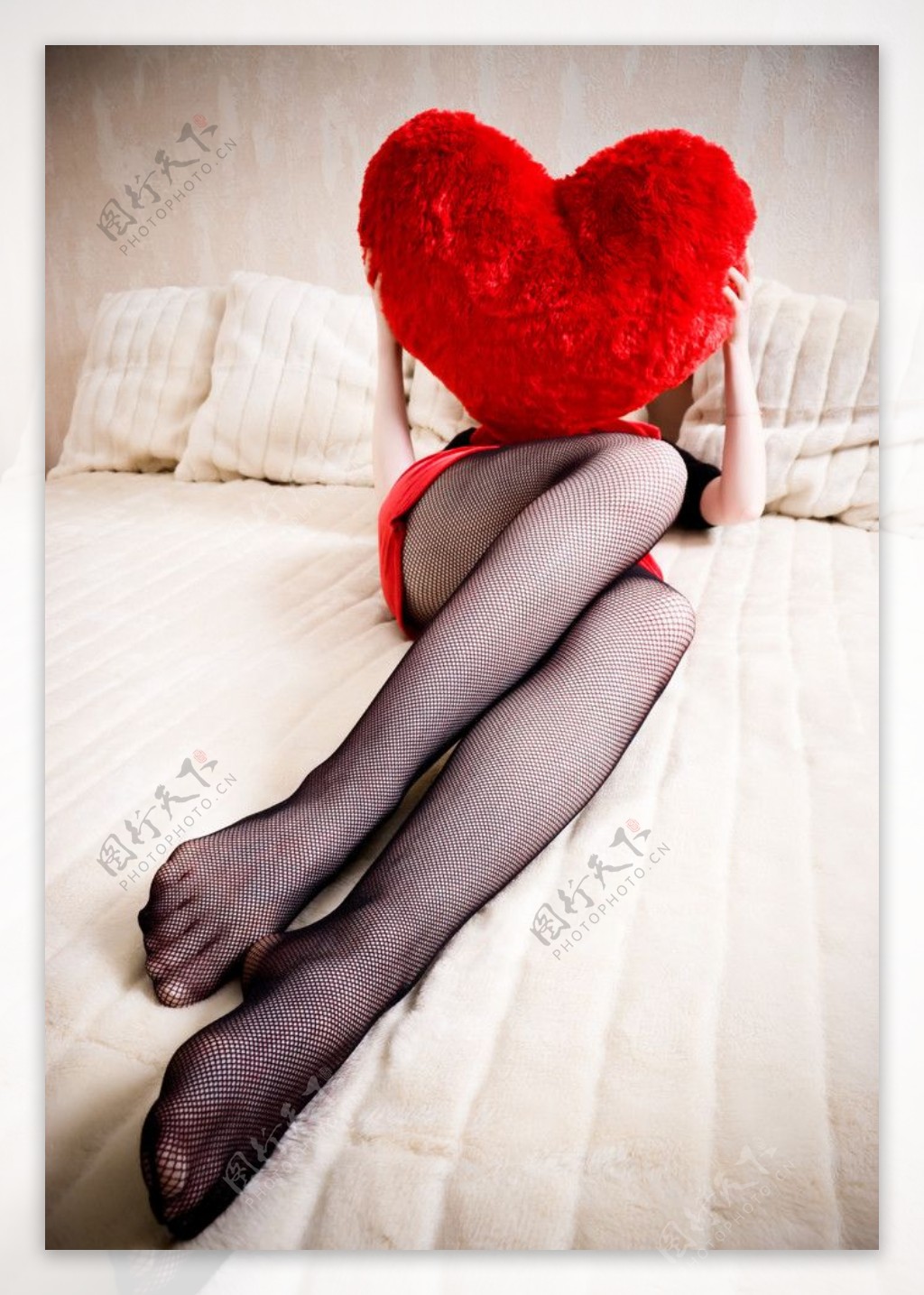 躺在床上拿着爱心枕头的性感美女图片
