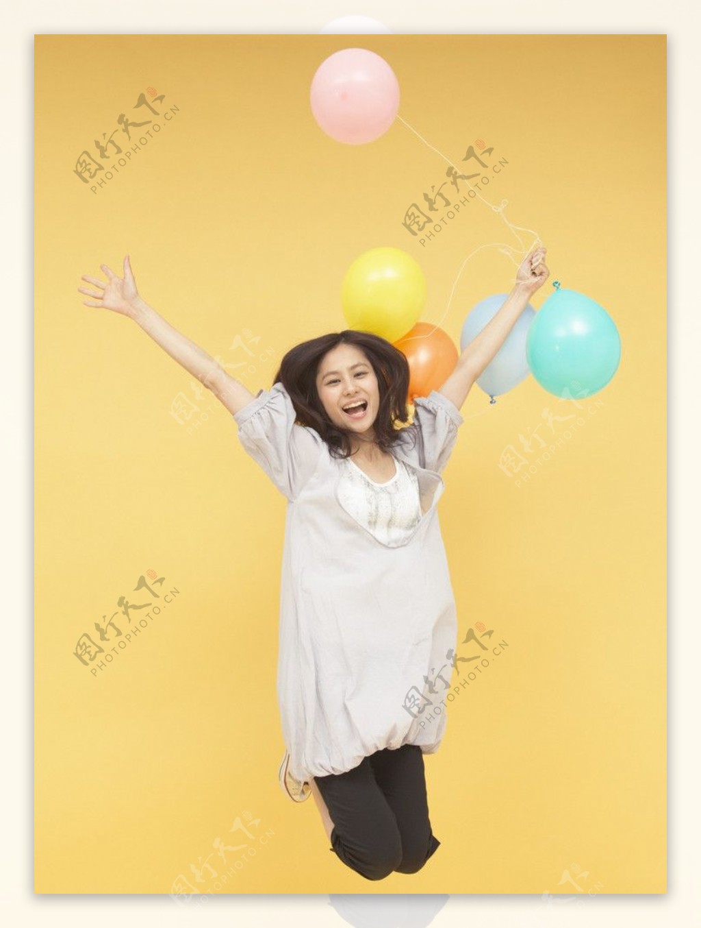 拿着彩色气球跳跃的美女图片