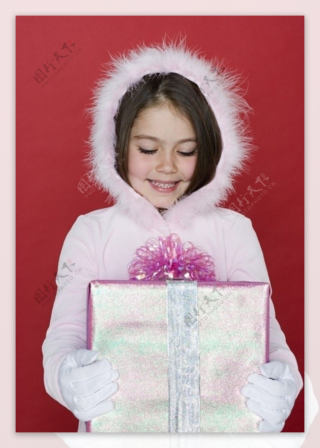 穿羽绒服抱着礼盒的甜蜜小女孩图片