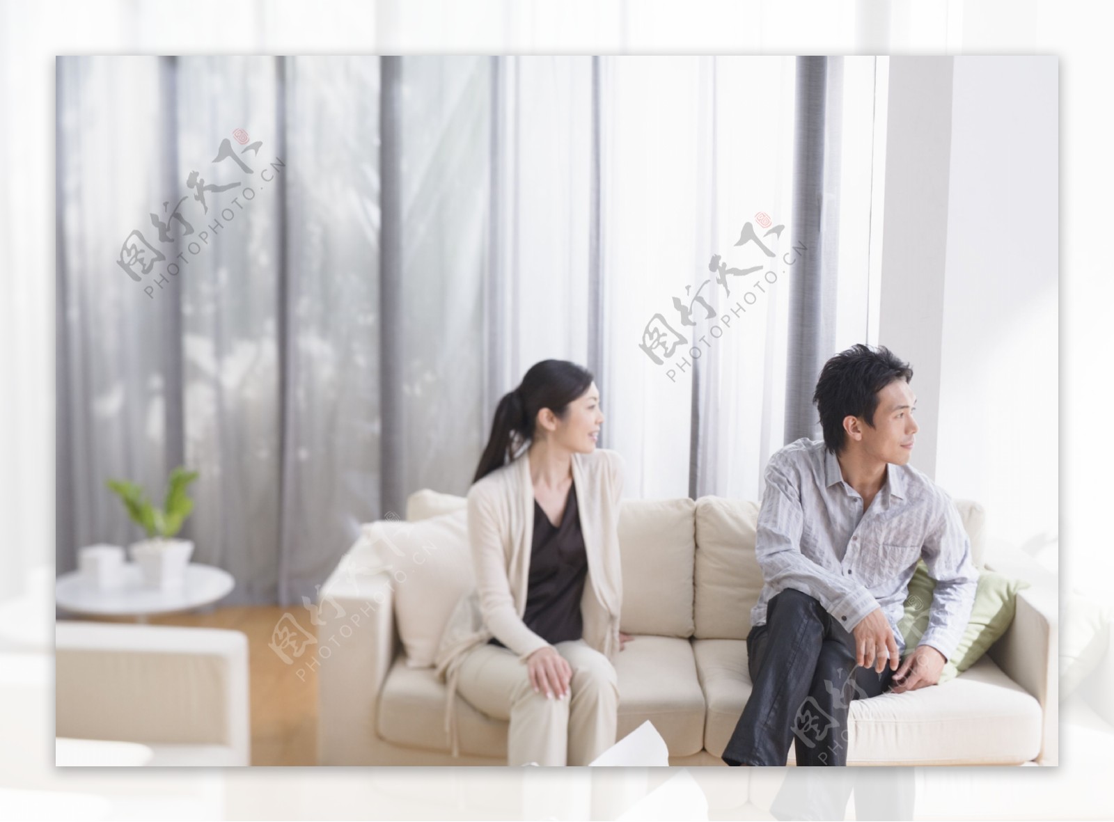 坐在沙发上的年轻夫妻图片