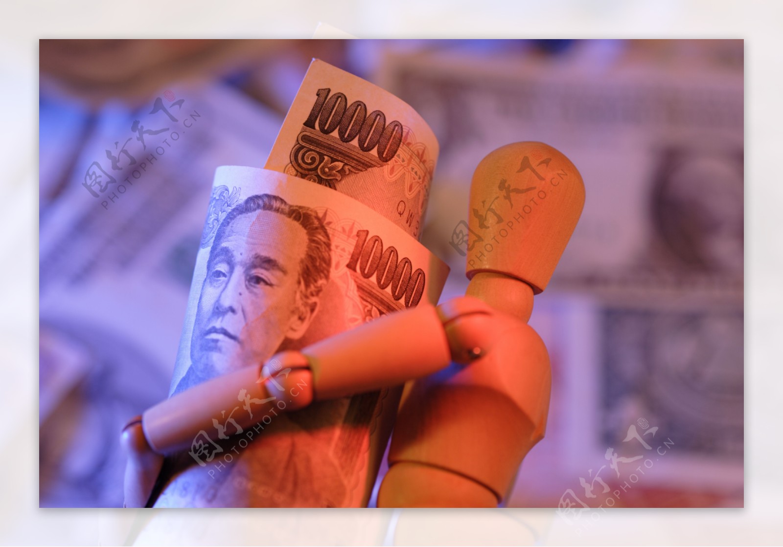 木偶人抱着的日元钞票特写图片