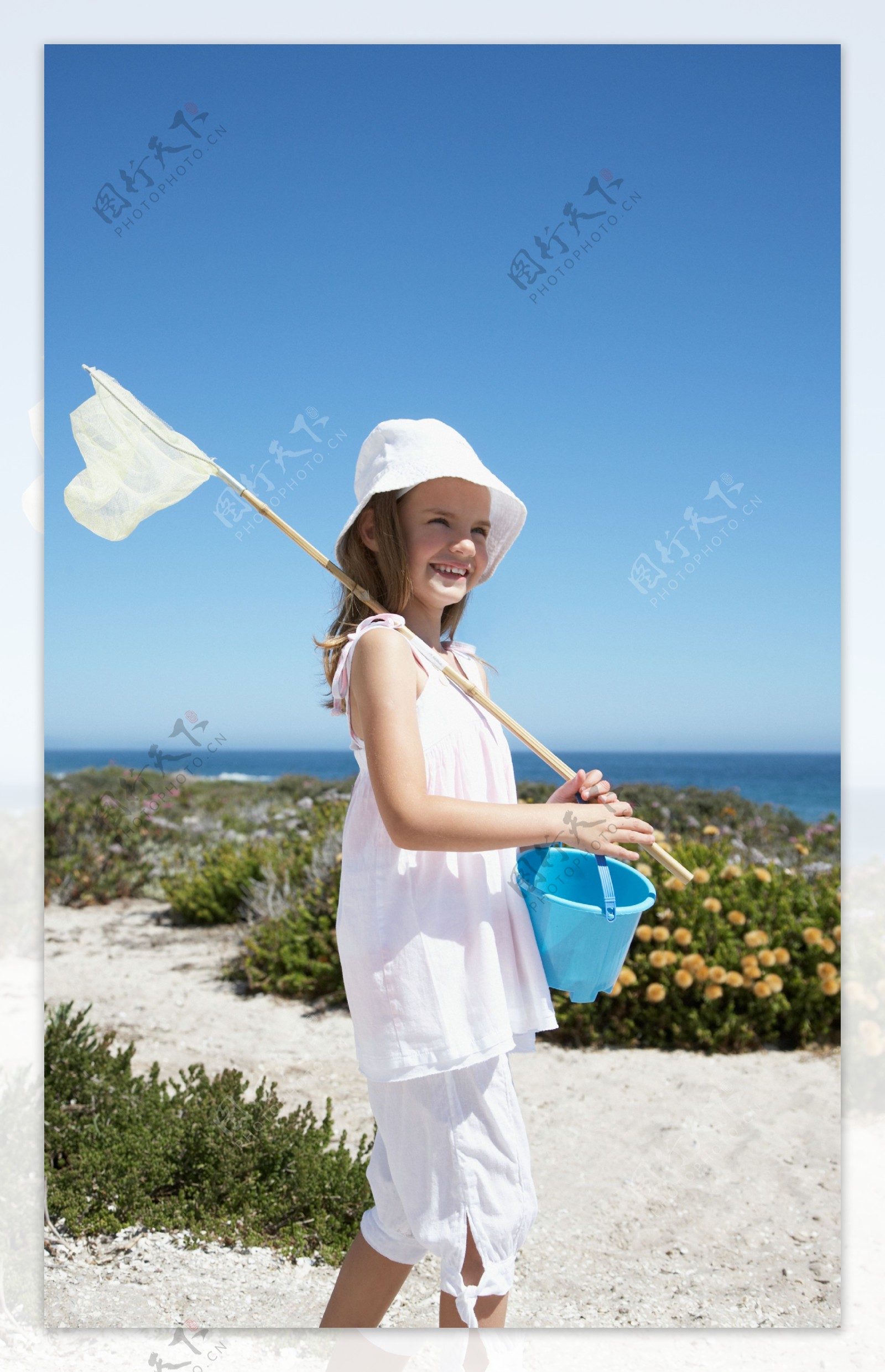 海边拿着捞鱼工具的小女孩图片