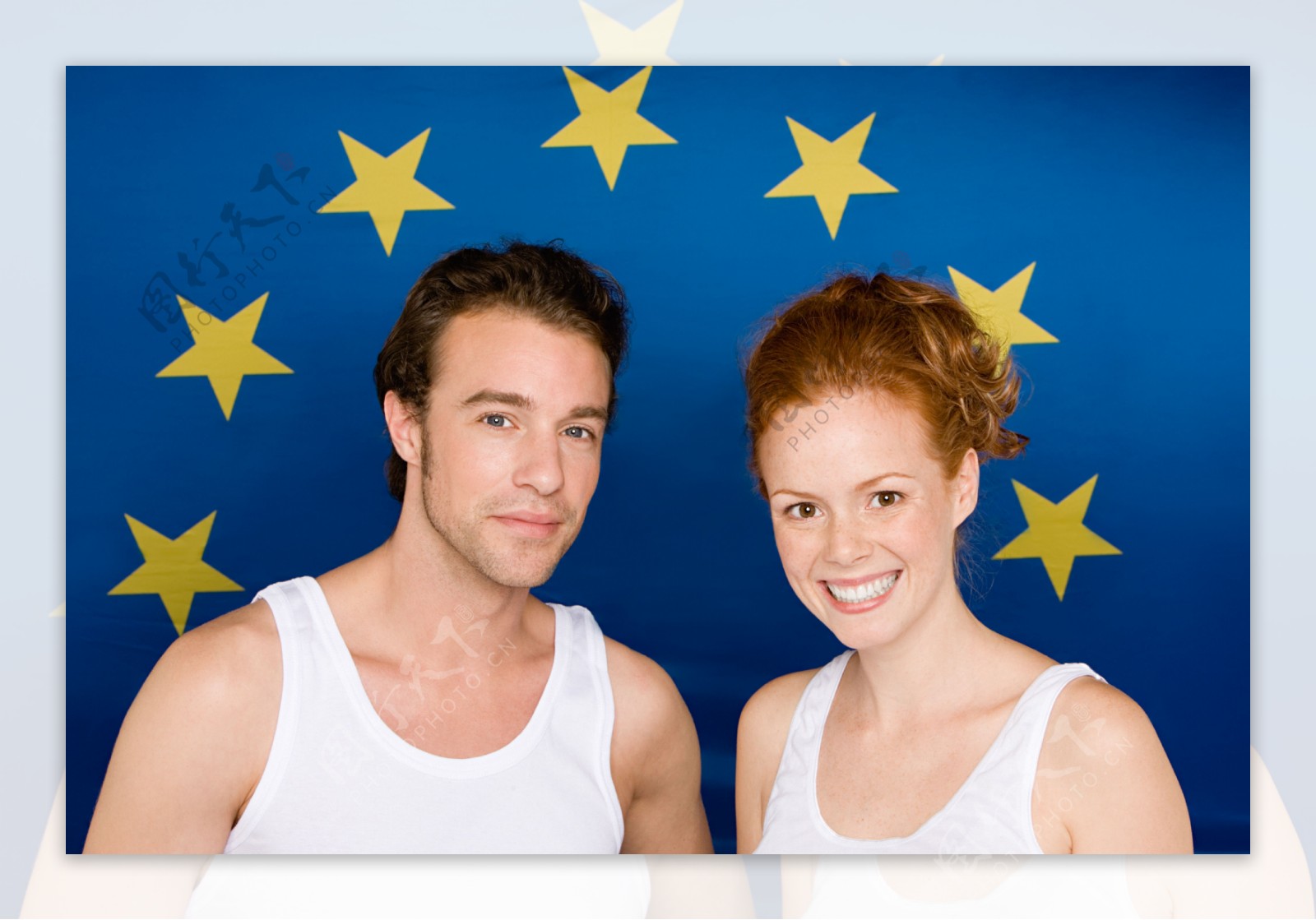 蓝色国旗背景前的外国夫妇图片