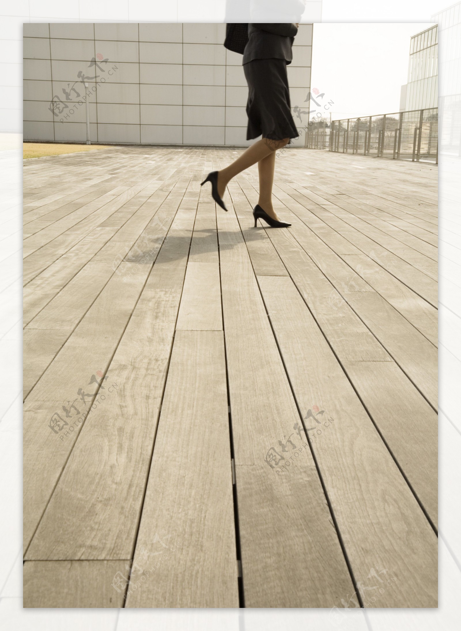 行走在木地板上的商务女性图片