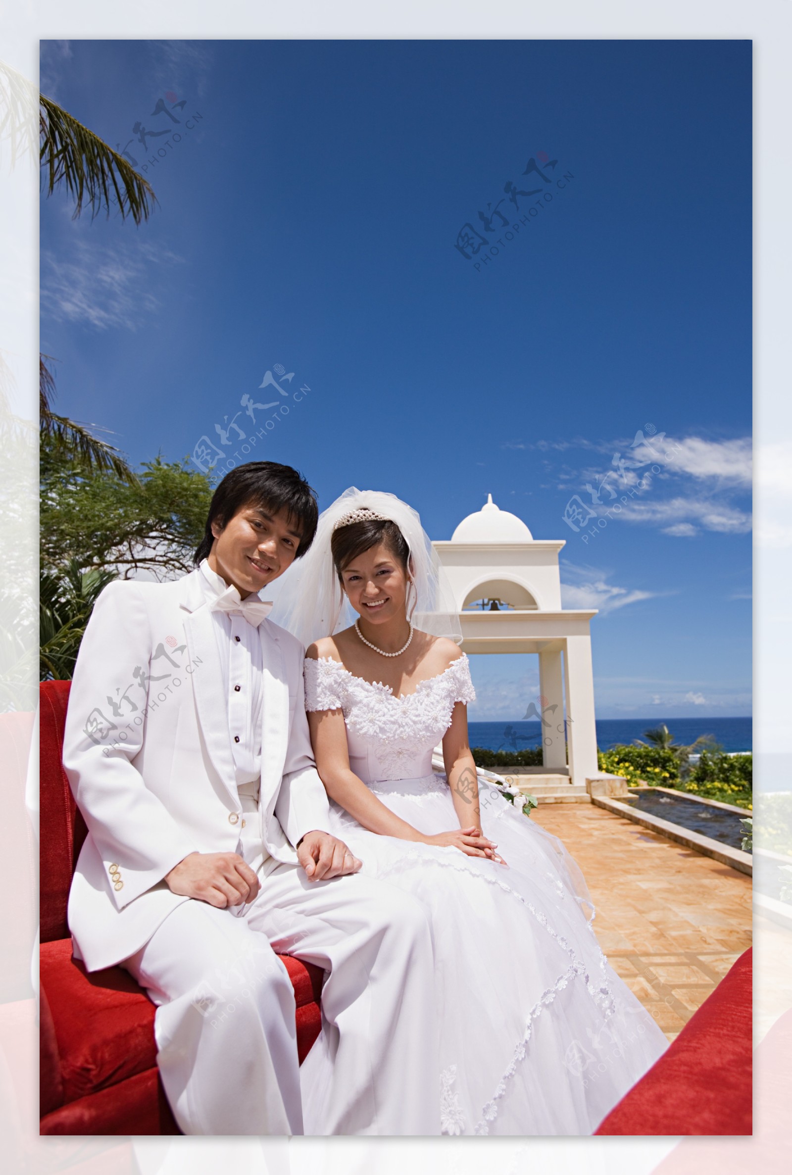 海边坐在一起面带微笑的新郎新娘图片图片