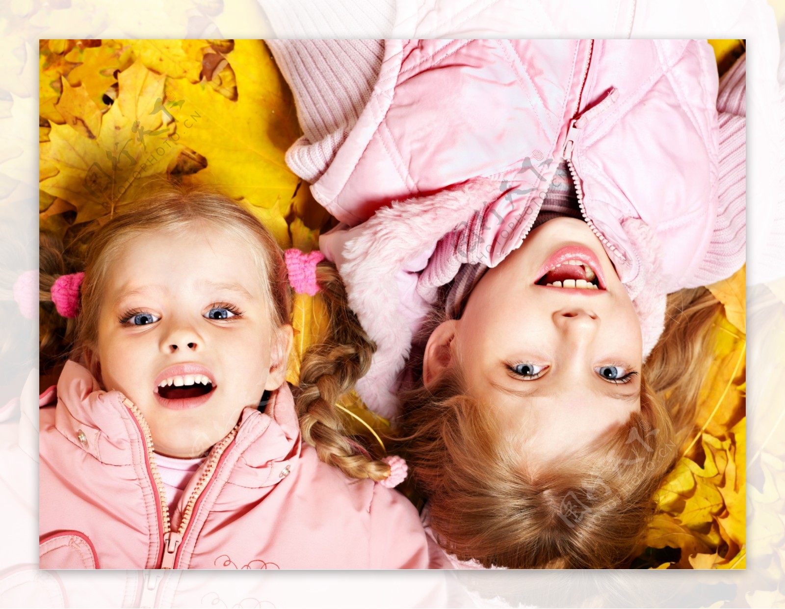 躺在黄色枫叶上的两个女孩图片