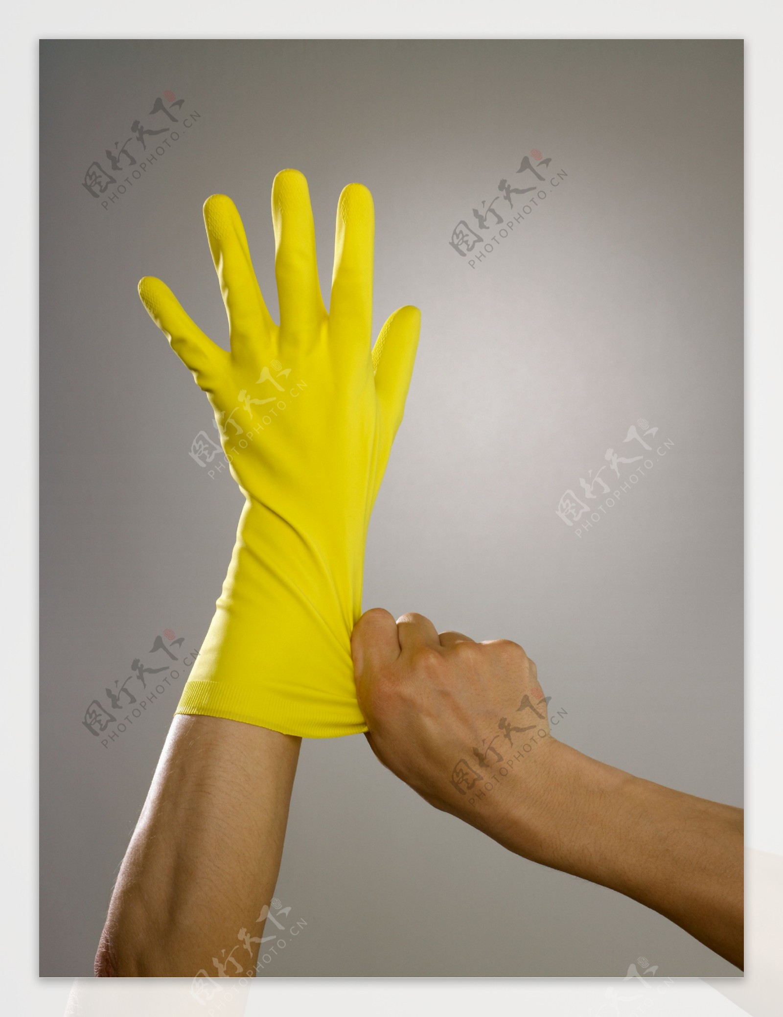 戴着黄色胶皮手套的手部特写图片图片