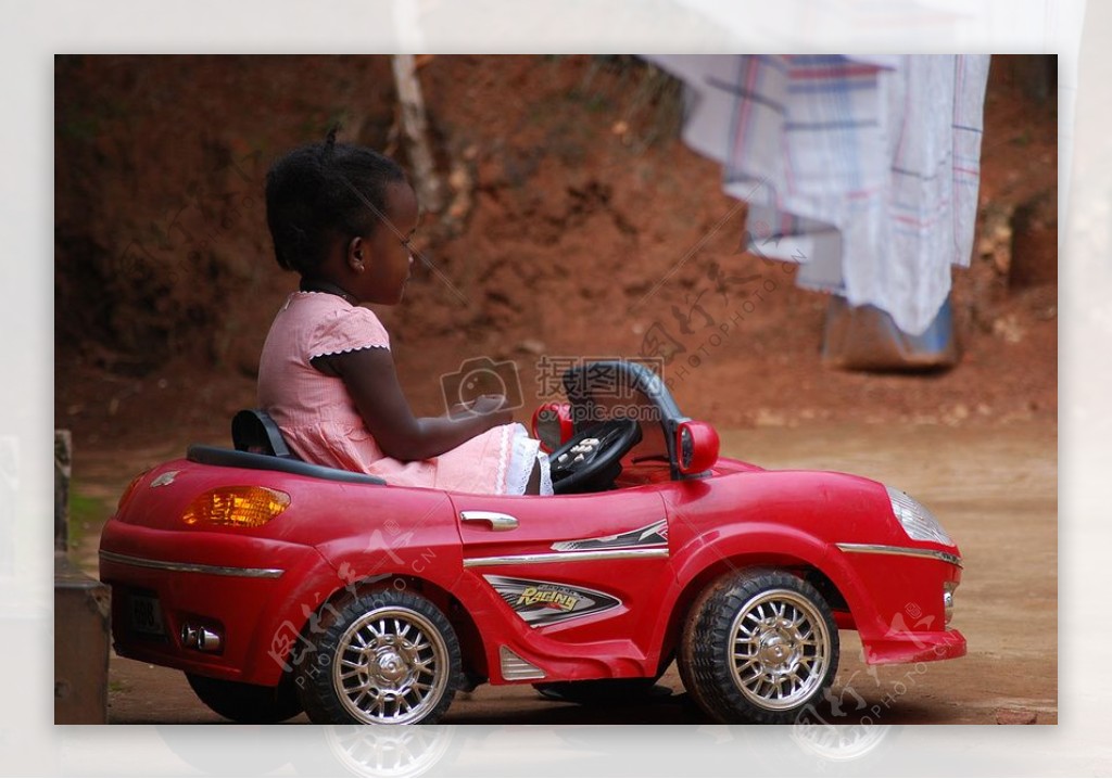 坐在红色玩具汽车的小孩