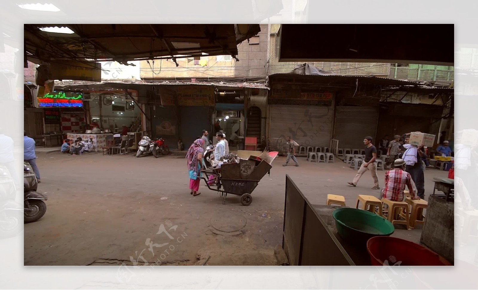 印度妇女在德里大街停放着一辆手推车