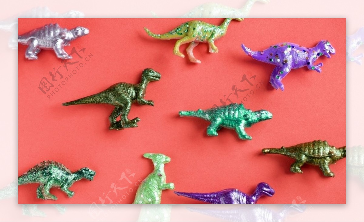 红色表面上的五颜六色的玩具恐龙